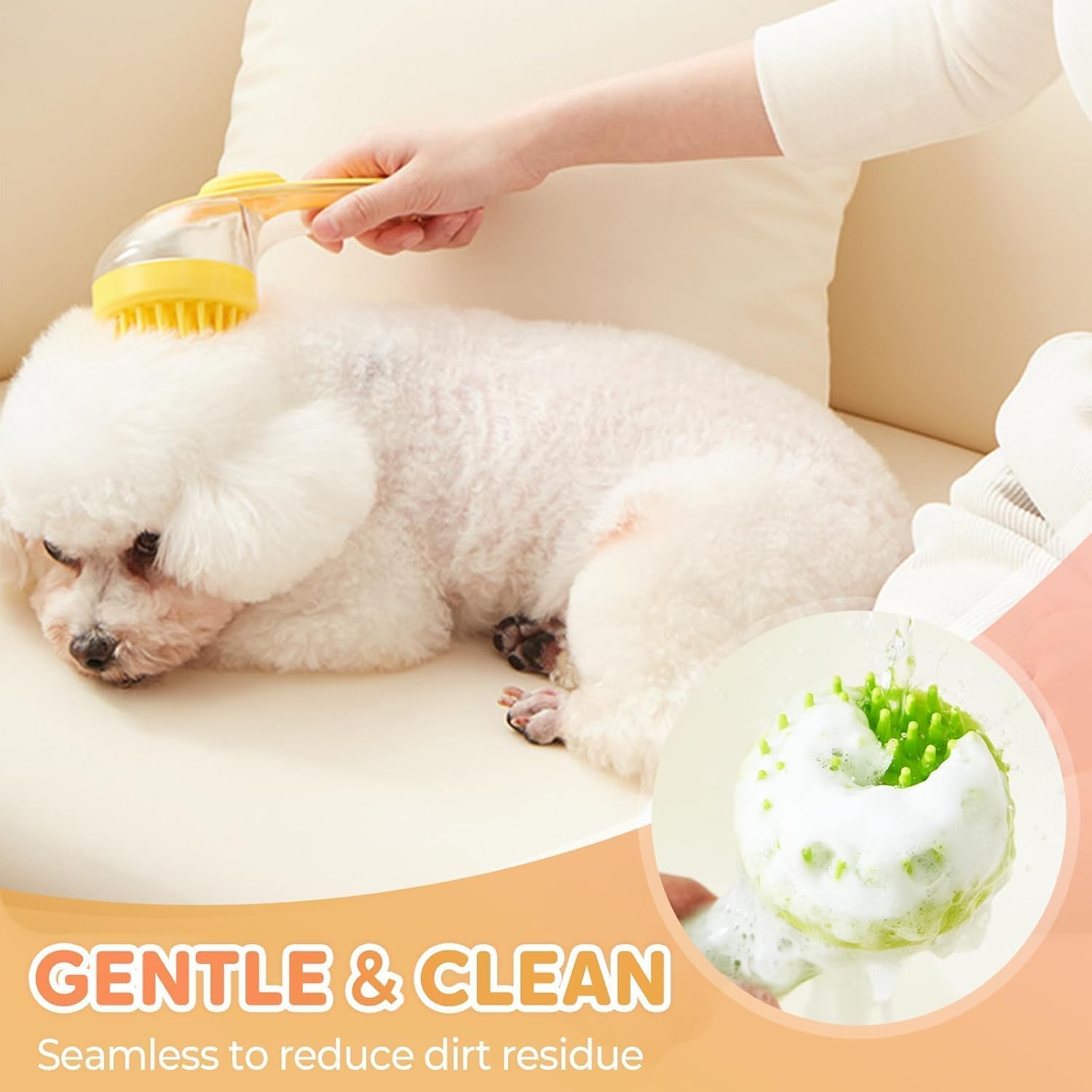 Hand brushing a white dog on a sofa, lather visible in the silicone brush head