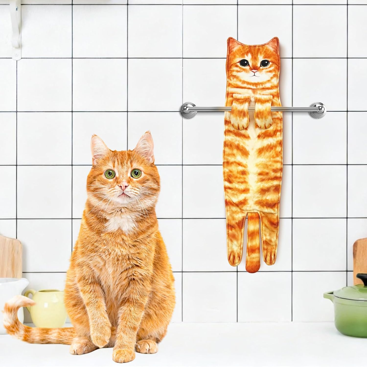 The cat towel hanging in a tiled kitchen next to a real ginger cat